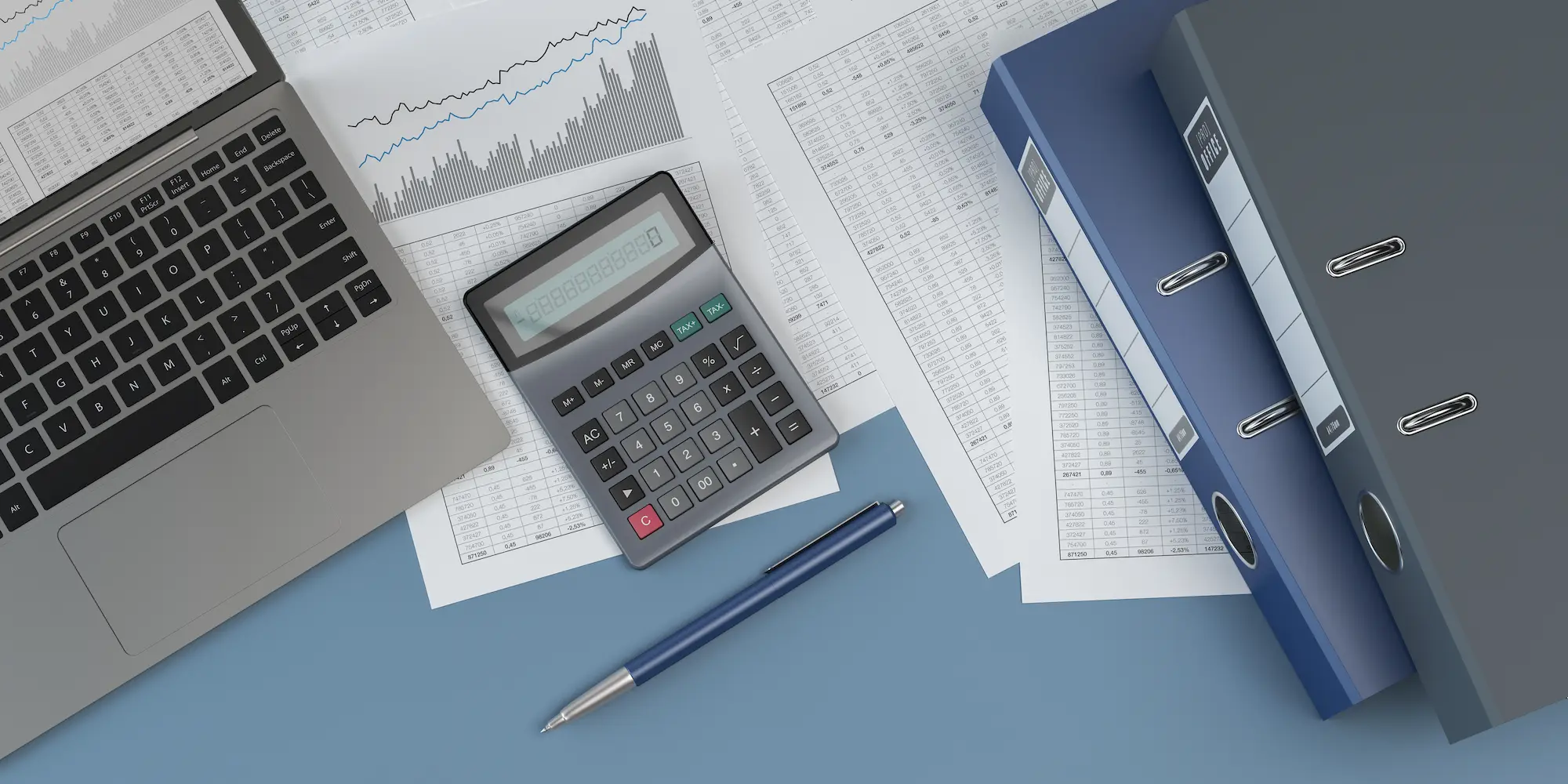 A laptop, calculator, blue pen, financial documents, and two blue binders are arranged on a blue desk, suggesting a workspace for accounting or financial analysis.